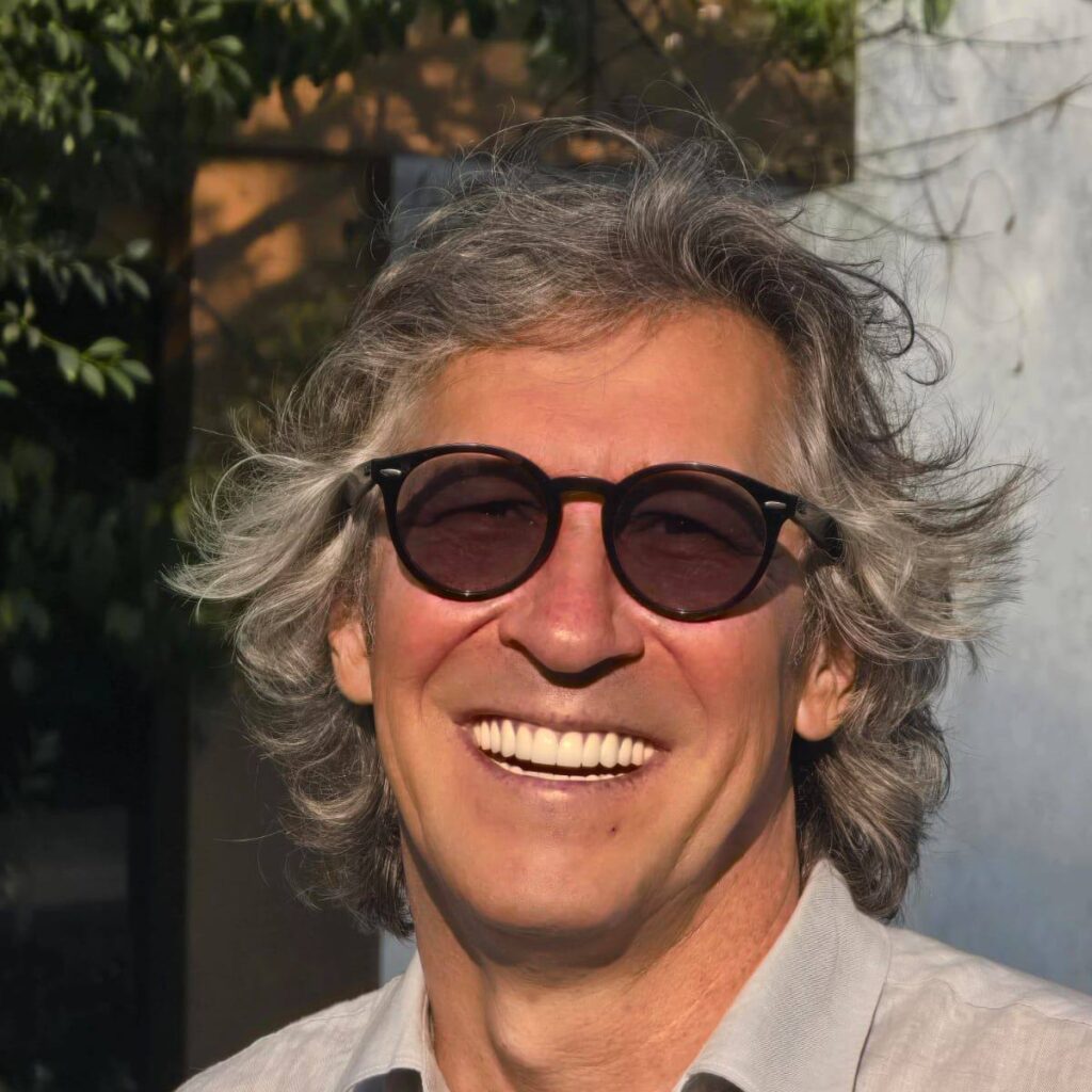 Director liceu special T&acirc;rgu Frumos st&acirc;nd &icirc;ntr-un birou, discut&acirc;nd cu un coleg, cu cărți și documente pe masă.